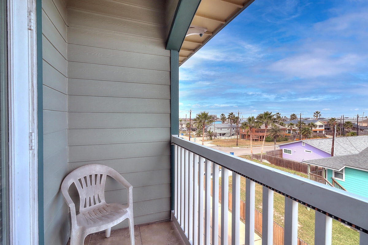 Step onto your private balcony and soak in colorful neighborhood views of charming coastal homes beneath endless blue skies.