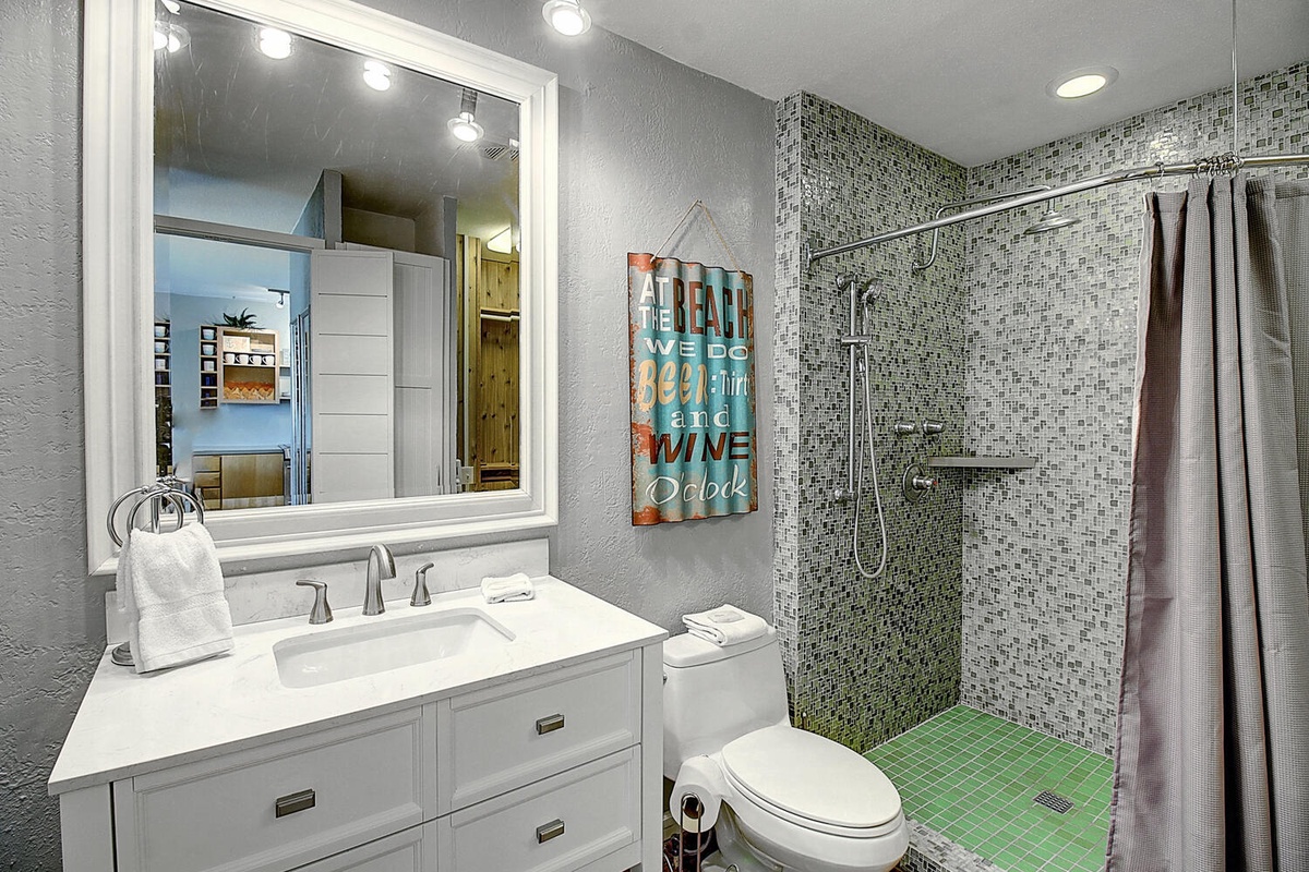 Refresh in this beautifully appointed bathroom with mosaic tile shower, modern vanity, and coastal touches that set the perfect vacation mood.