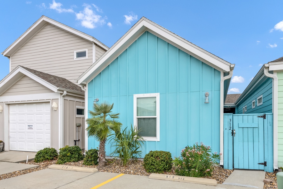 Colorful coastal homes with tropical landscaping create a charming beachside community setting.