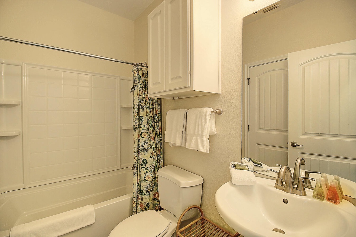 Step into your private bathroom featuring a relaxing tub-shower combo, fresh towels, and thoughtful amenities waiting for your arrival.