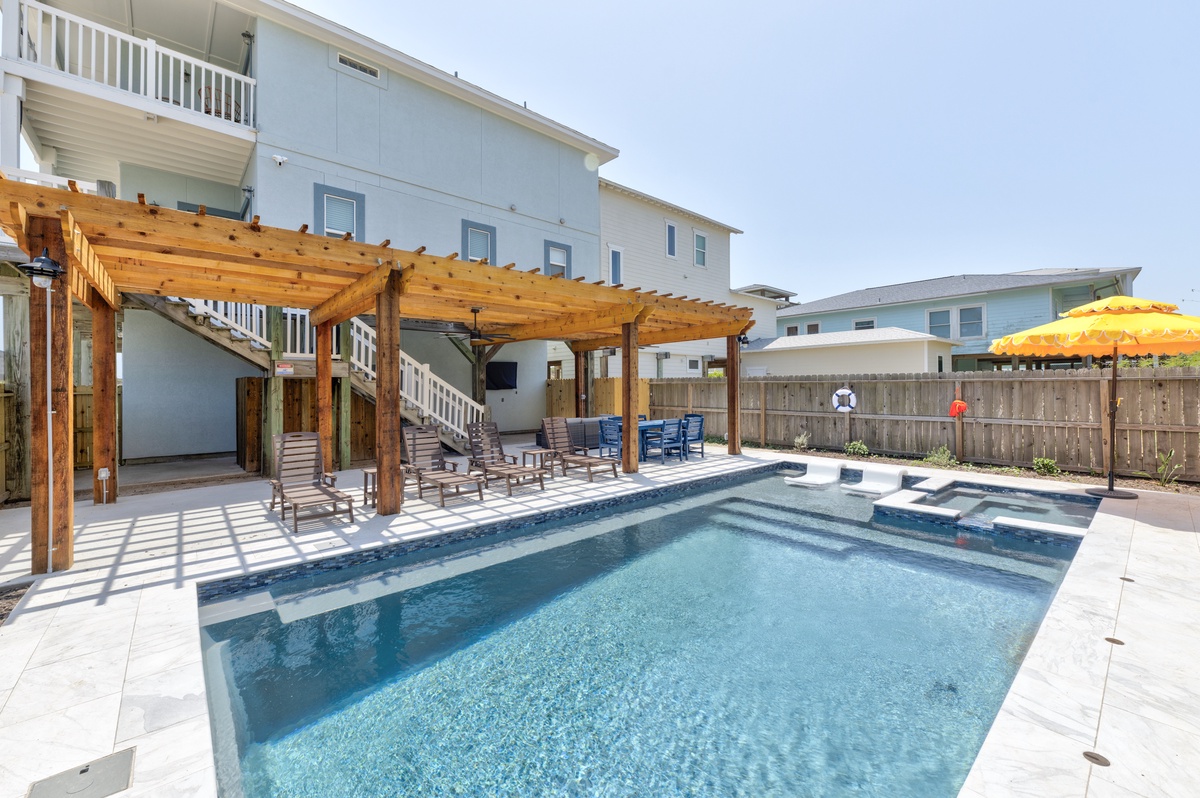 Your private oasis awaits with a sparkling pool, covered pergola for shade, and poolside seating perfect for sunny afternoons and evening relaxation.