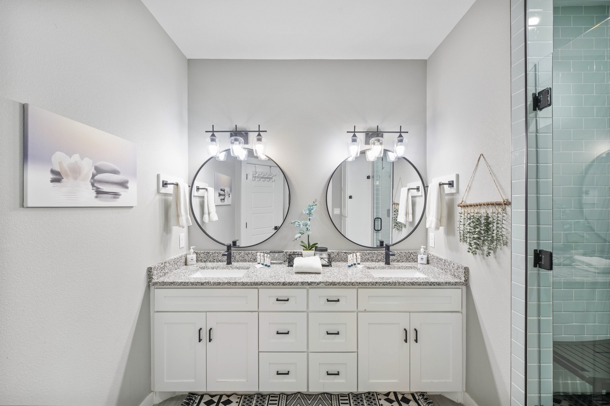 Refresh in your stylish double vanity bathroom with granite countertops, sleek black fixtures, and a spacious walk-in shower.