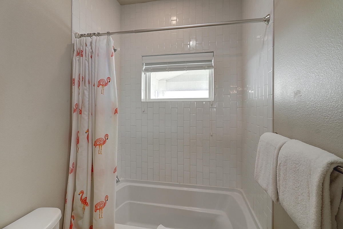 Refresh in your private bathroom with a cheerful flamingo-print shower curtain and fluffy white towels waiting for you.