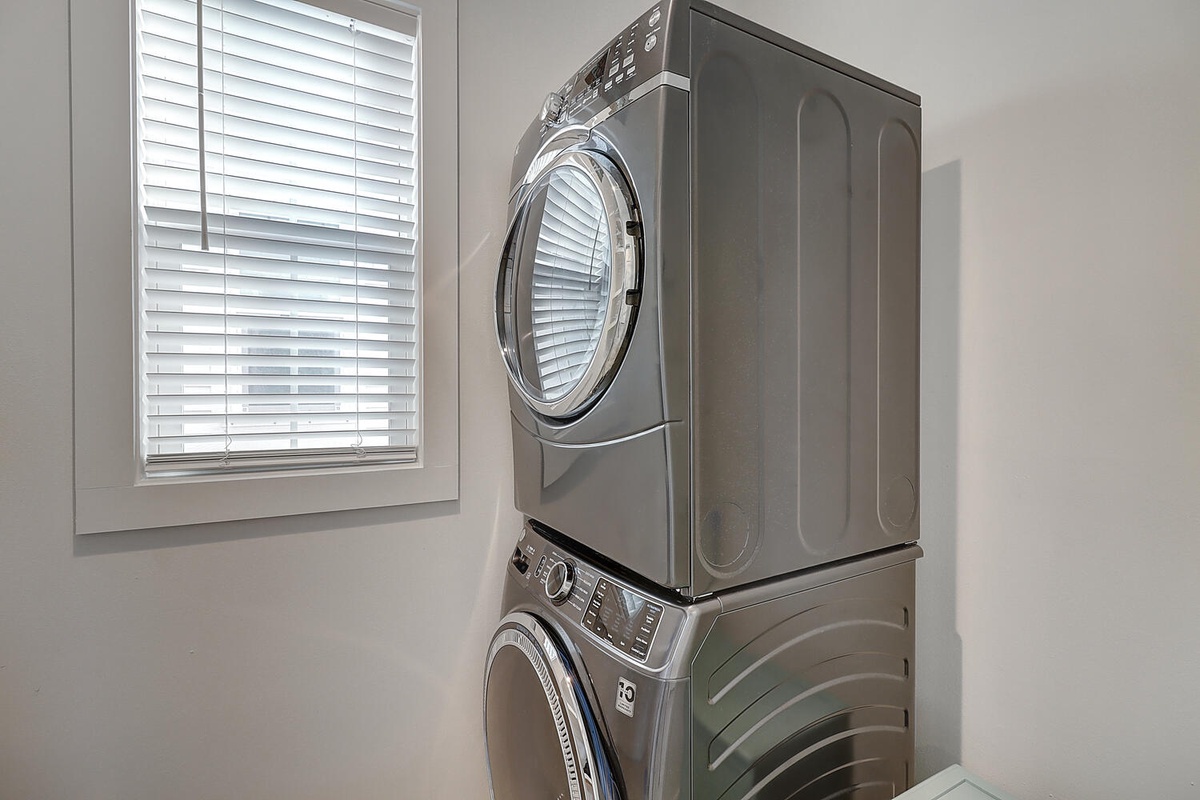 Your laundry days just became effortless with this pristine stacked washer and dryer setup in your dedicated laundry room.