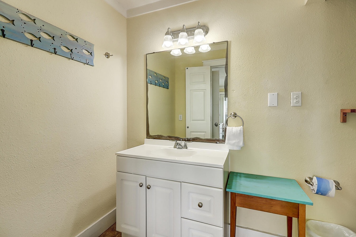 Your private bathroom features a bright vanity with ample storage and charming coastal touches that create a refreshing morning routine.