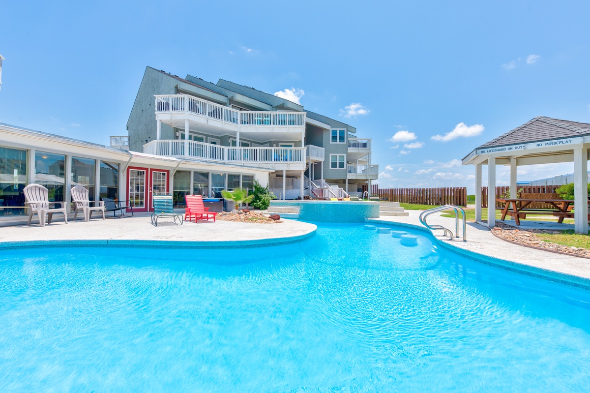 Stunning beachfront property featuring a custom lazy river pool and multiple outdoor living spaces for the ultimate coastal getaway.