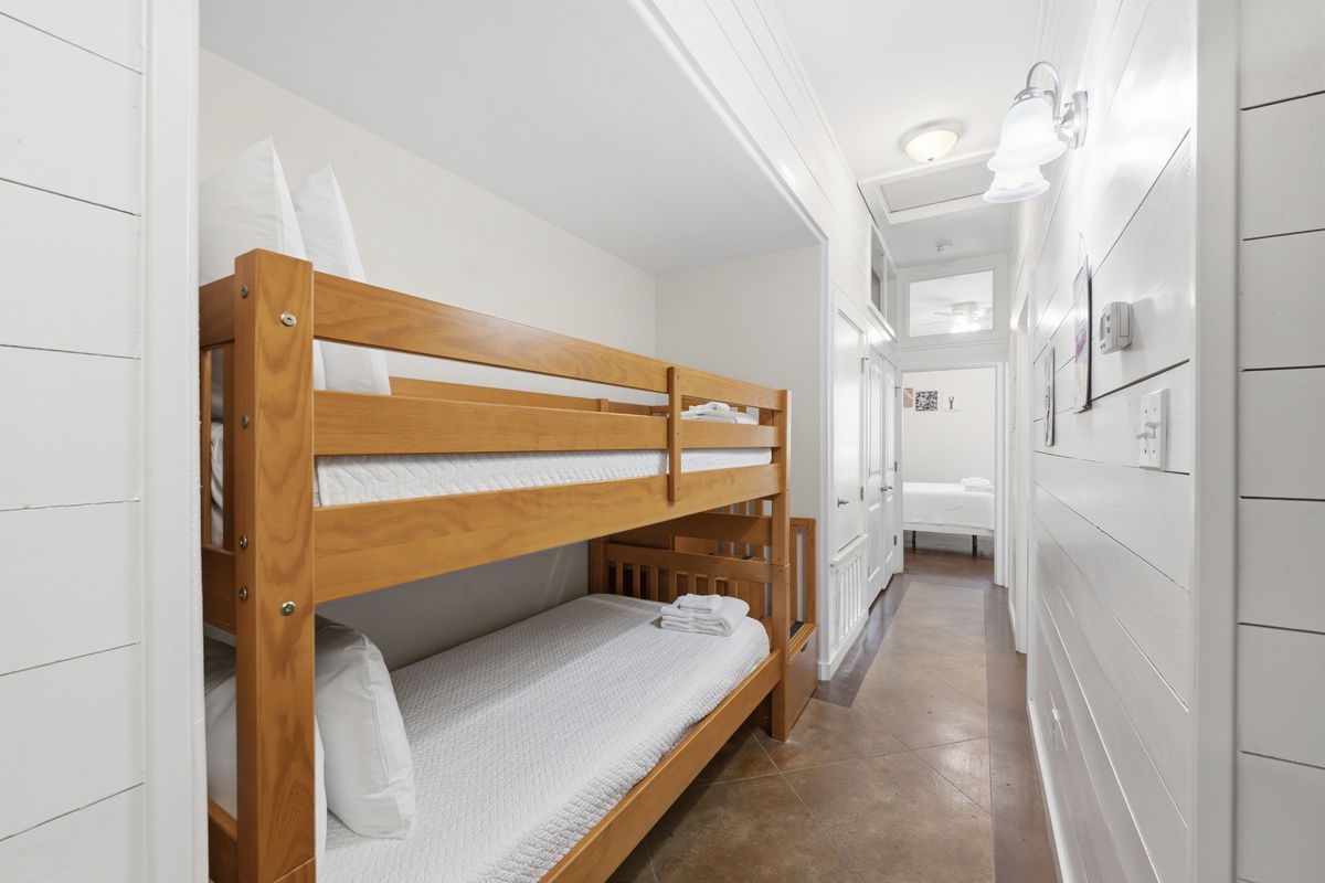 Your cozy bunk room is thoughtfully designed with warm wood tones and crisp white linens, perfect for kids or friends sharing memories in this bright, welcoming space.