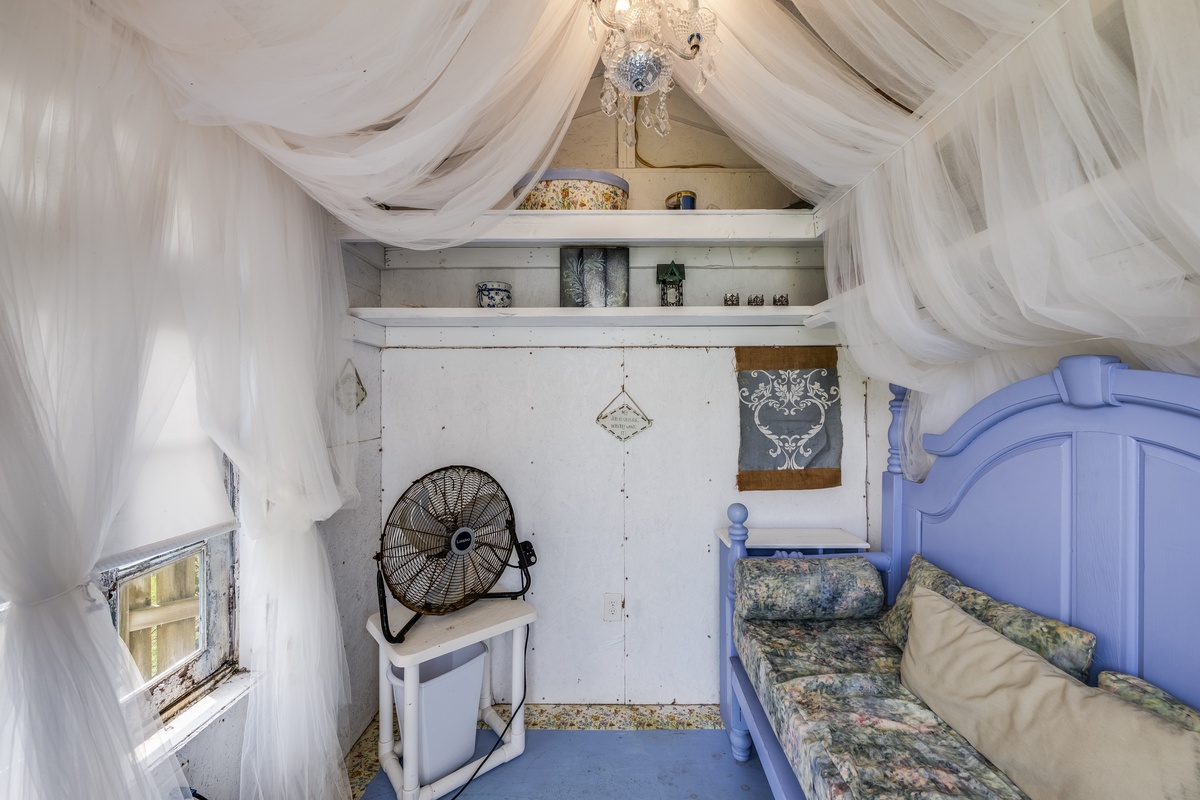 Step into your cozy loft retreat with charming details and soft draped fabrics overhead, where rustic warmth meets whimsical cottage style—perfect for unwinding in comfort.