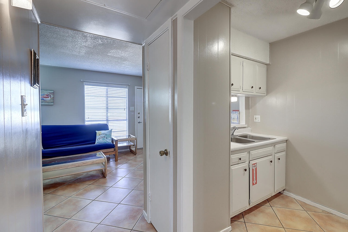 Your compact kitchen features bright white cabinetry and everything you need to prepare meals during your getaway.