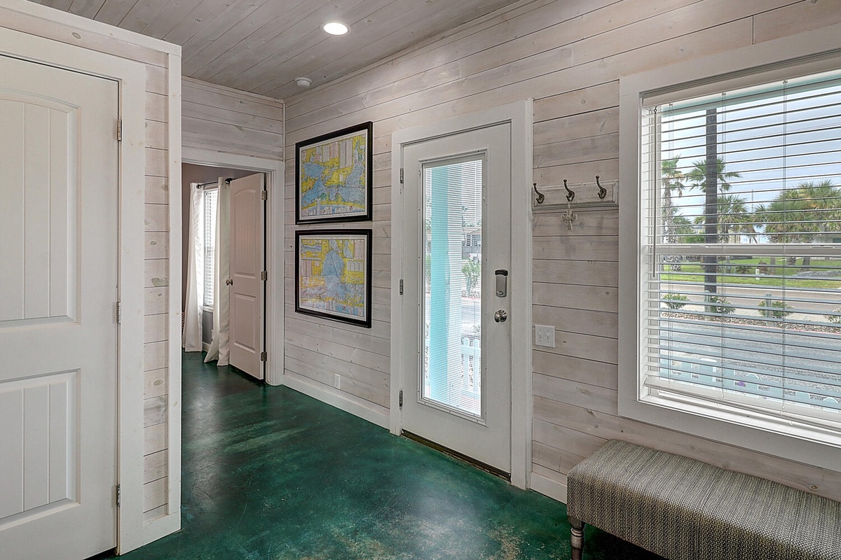 Your coastal entry welcomes you with weathered wood walls and vibrant green floors that hint at seaside adventures ahead.