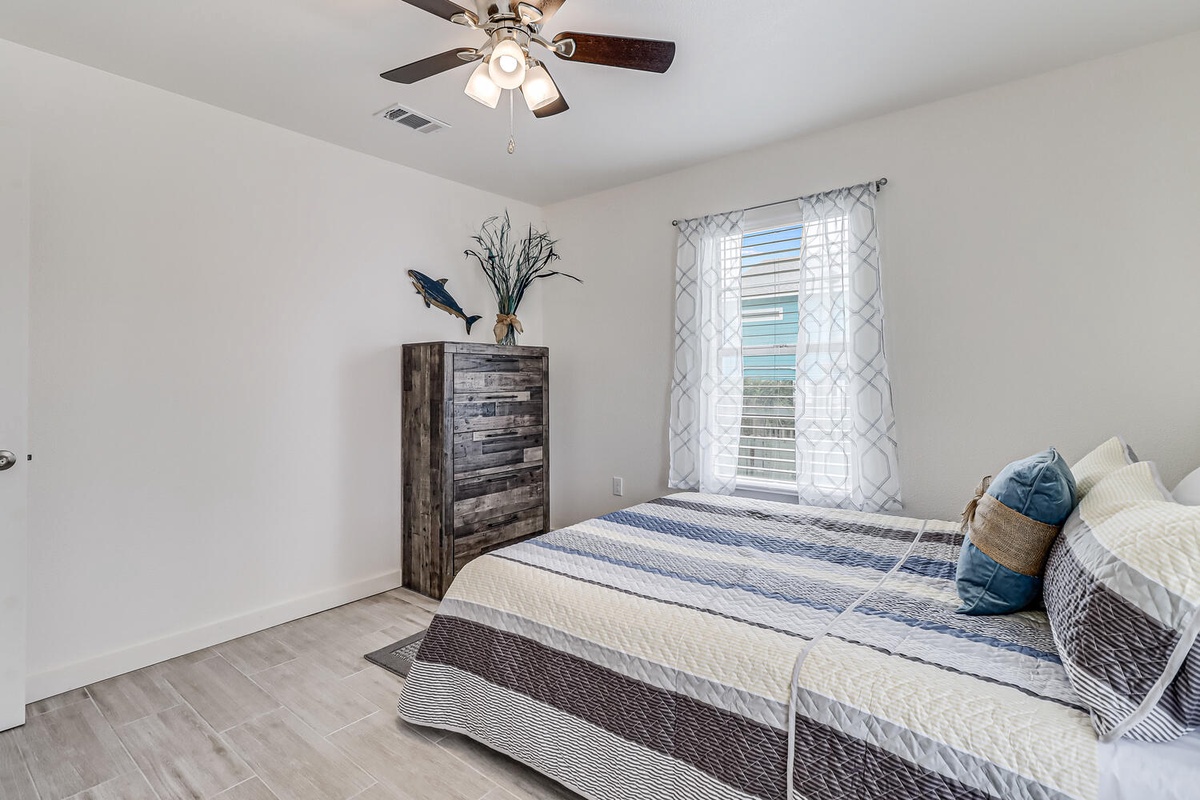Rest easy in your peaceful bedroom with comfortable bedding, rustic touches, and a gentle ceiling fan to keep you cool.