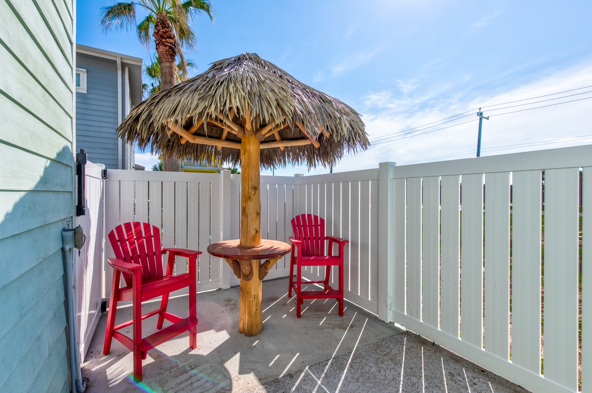 Relax at your private tiki bar with tropical vibes, complete with red Adirondack chairs and thatched umbrella shade.