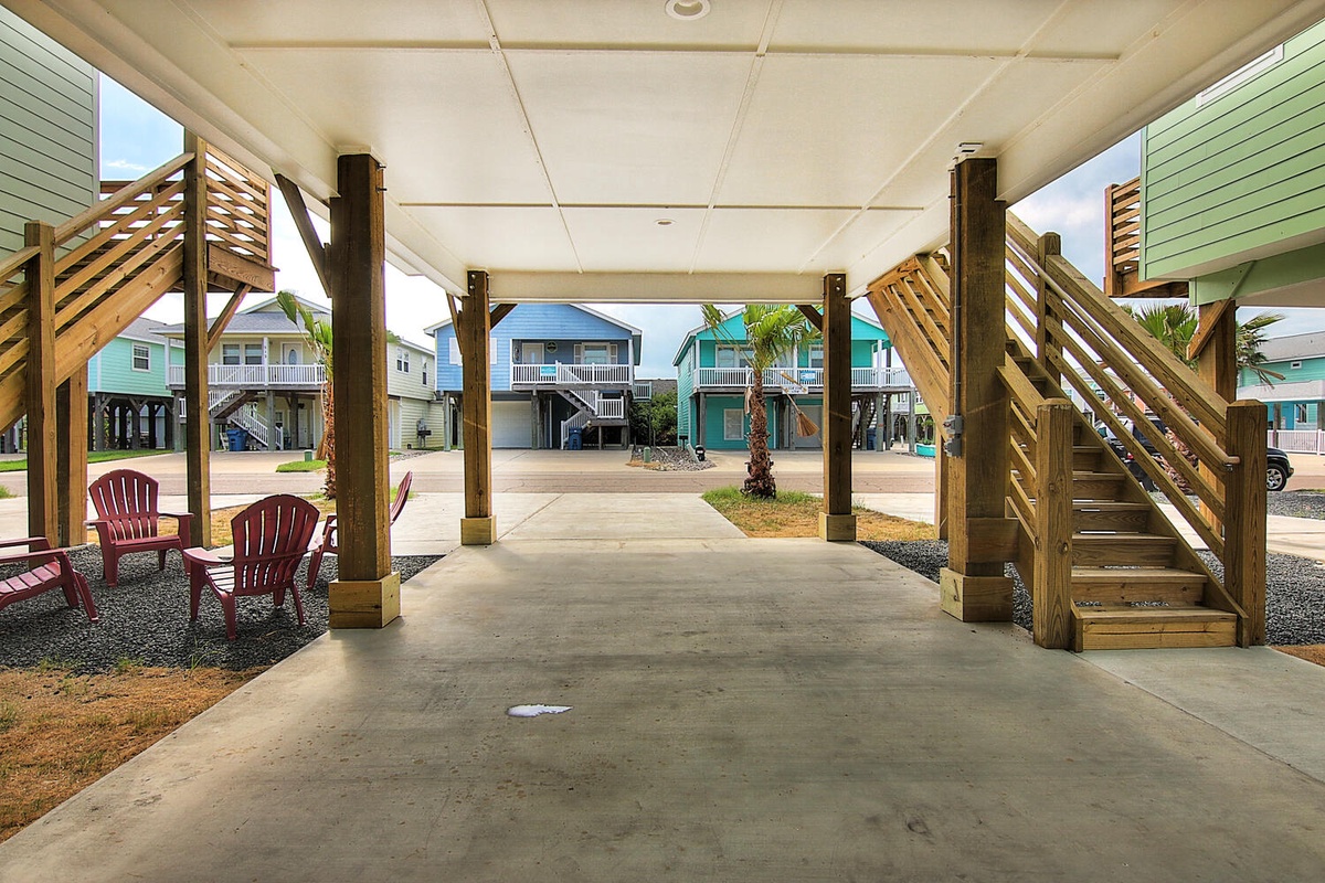Park right under your beachside retreat with covered parking and relax in the red chairs before heading upstairs to your coastal getaway.