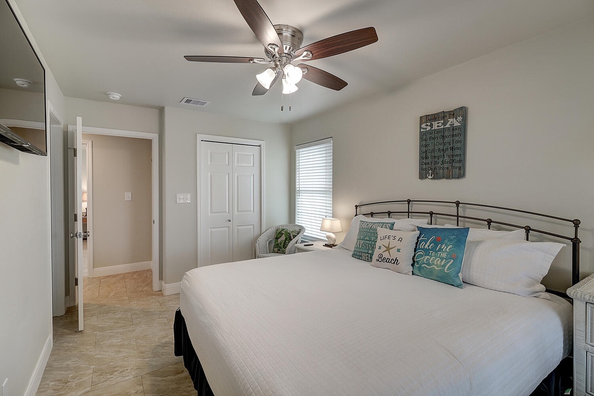 Drift off peacefully in this bright bedroom with coastal-themed pillows, a ceiling fan for comfort, and your own flat-screen TV.