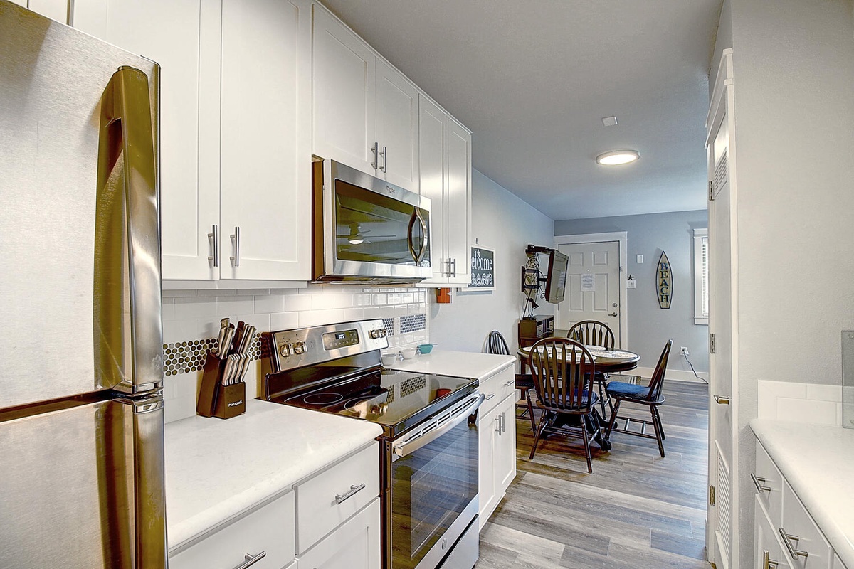 Your spacious kitchen features stainless steel appliances, white cabinetry, and flows seamlessly into a cozy dining area where you can enjoy meals together.