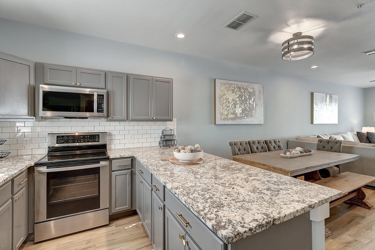 Your modern kitchen flows seamlessly into the dining space, featuring granite counters and stainless appliances for memorable meals together.