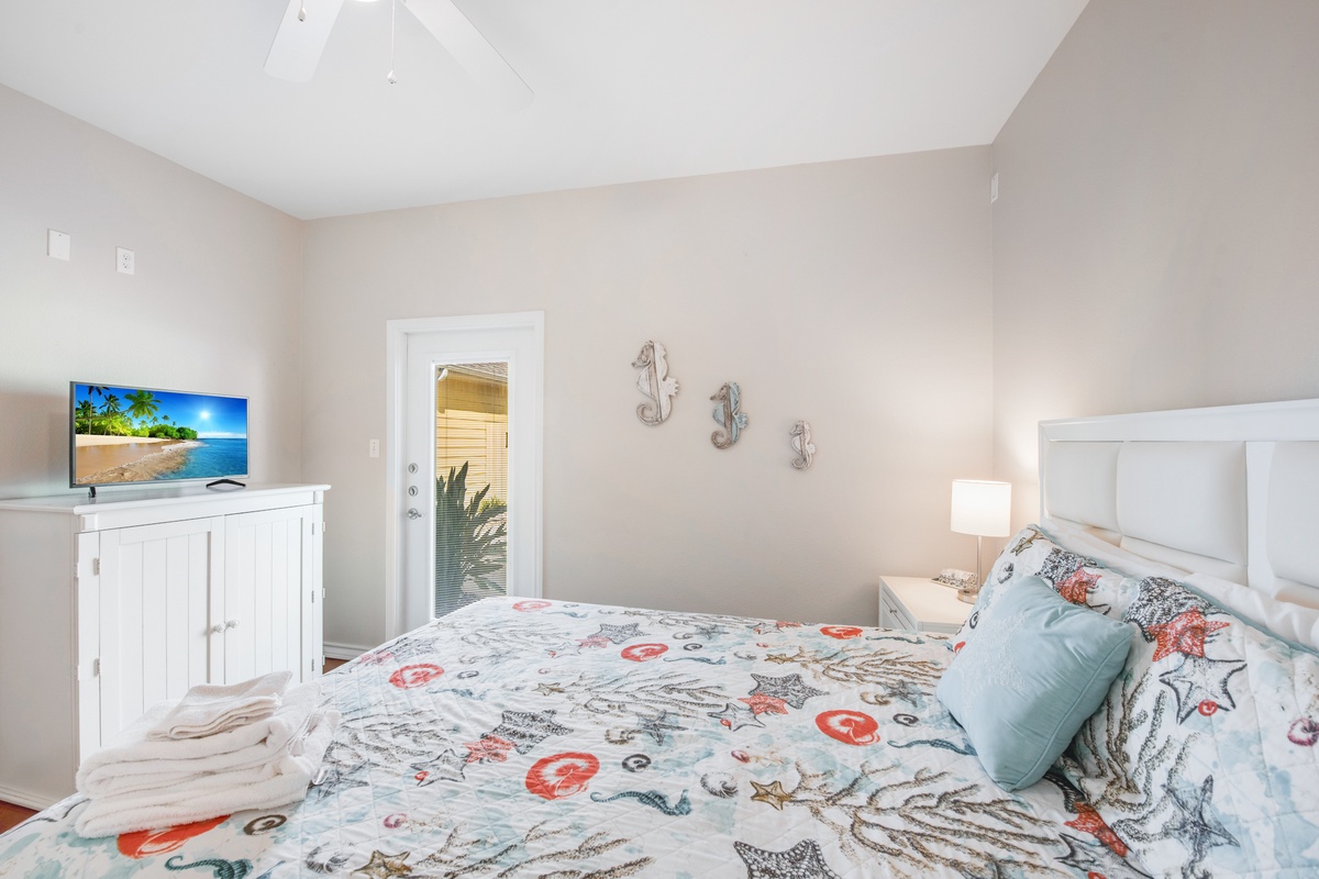 Drift off to sleep in this bright coastal bedroom with ocean-themed bedding, flat-screen TV, and charming nautical touches that make you feel seaside.