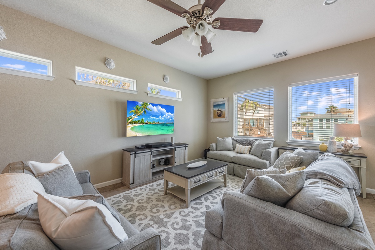 Sink into plush gray sofas in your spacious living room, where tropical scenes on the big screen set the mood for relaxation.