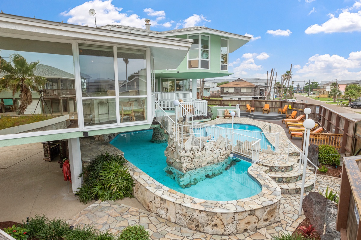 This stunning beachside property features a unique multi-level pool with stone accents and tropical landscaping perfect for your coastal getaway.