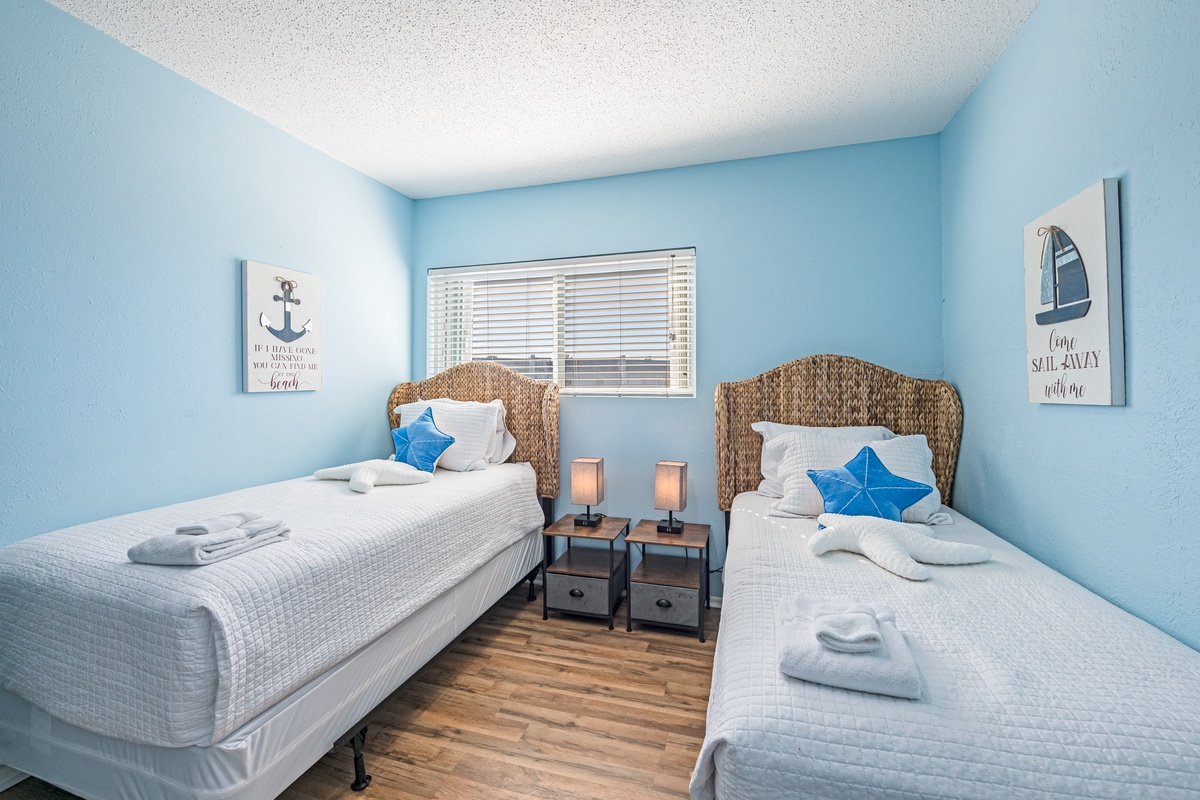Drift off in this coastal-themed twin room where soft blue walls and nautical artwork create your serene seaside retreat.