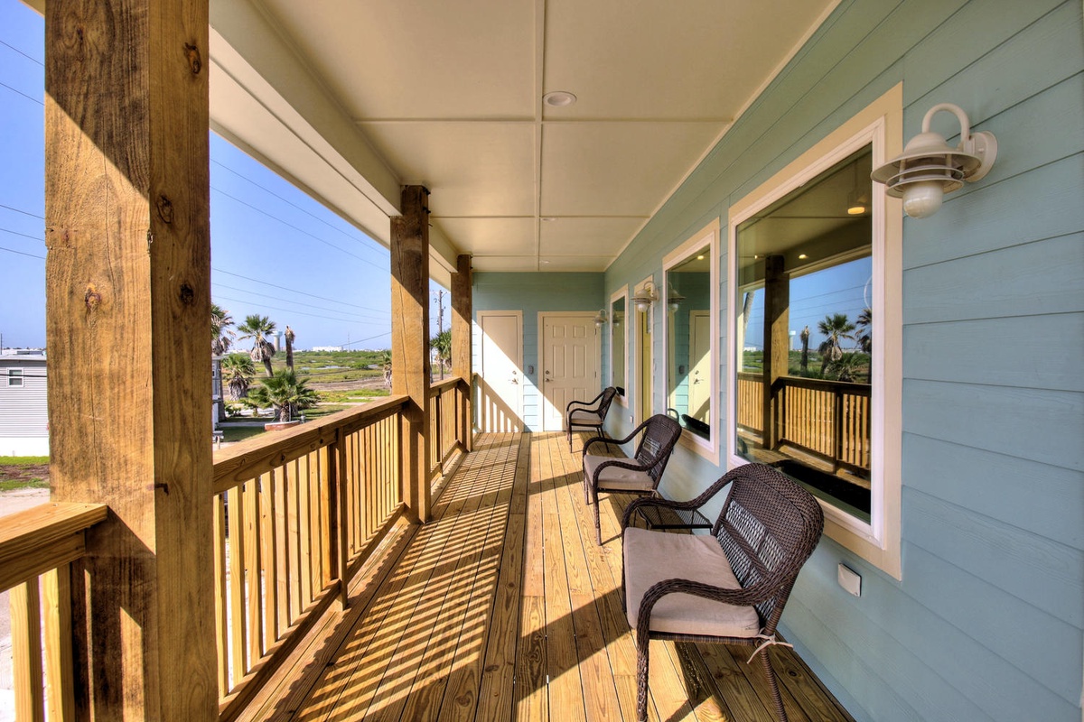 Settle into wicker chairs on your private porch, where coastal breezes meet palm-dotted views through oversized windows.
