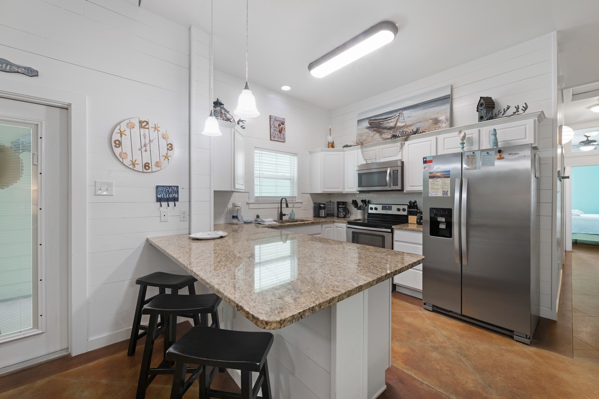Cook together in this bright, fully-equipped kitchen with granite countertops, stainless appliances, and breakfast bar seating for casual meals.