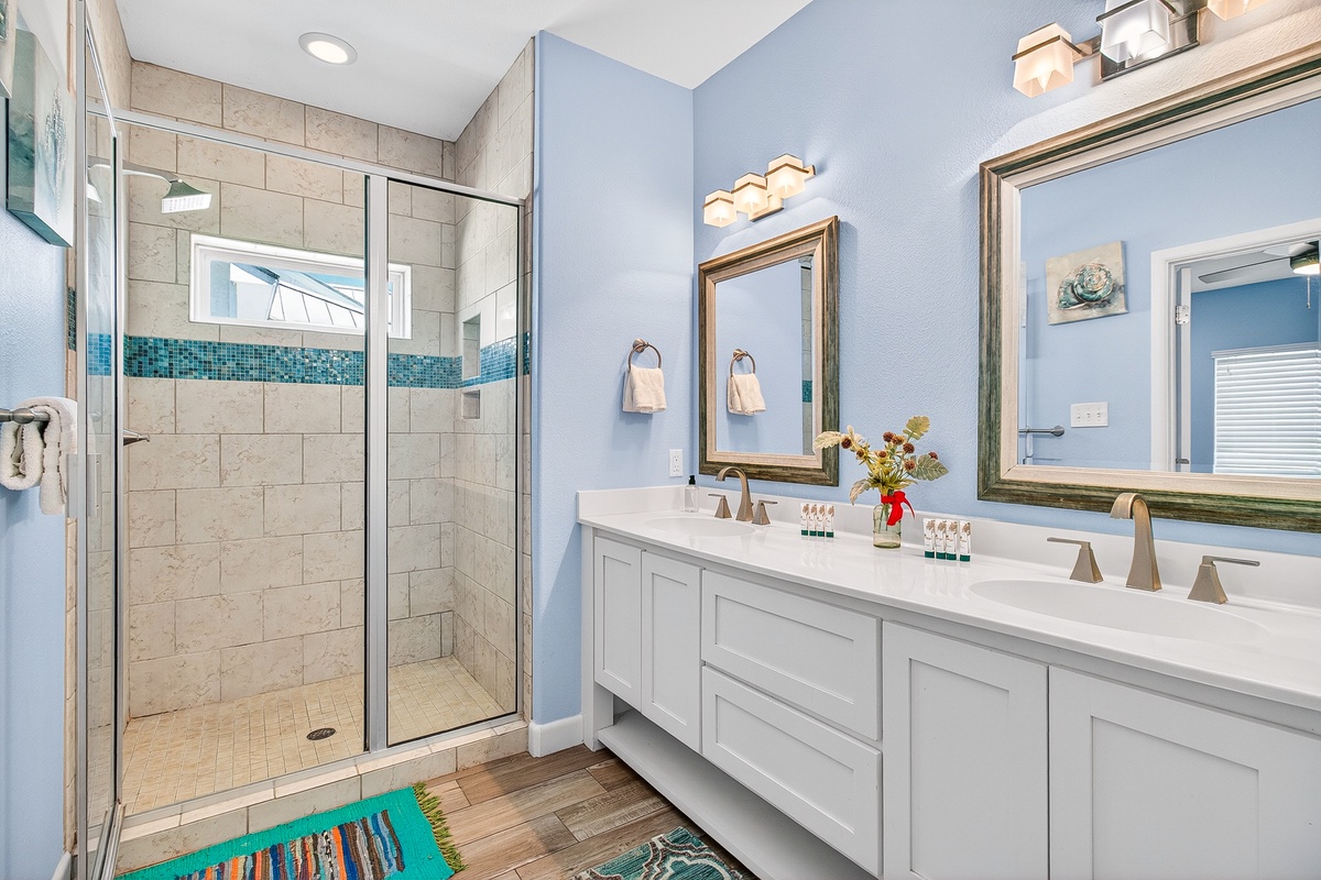 Refresh in your spa-like bathroom featuring a spacious walk-in shower and elegant double vanity with coastal-inspired touches.