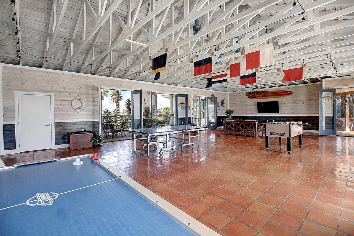 Your private game room awaits with ping pong, foosball, and shuffleboard under soaring nautical-themed ceilings - perfect for friendly competition.