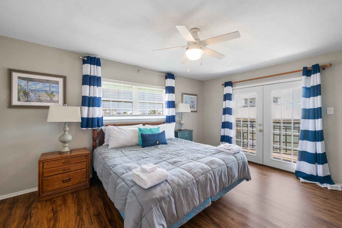Your coastal-inspired bedroom offers a peaceful retreat with nautical charm, fresh ocean breezes from the balcony, and soft light that invites restful sleep after sun-filled days.