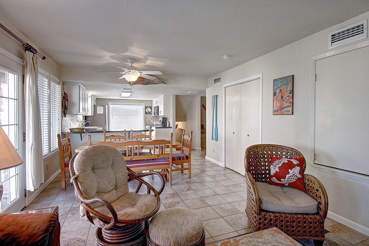 Relax in your open-concept living space with wicker chairs, dining table, and kitchen - perfect for memorable vacation meals together.