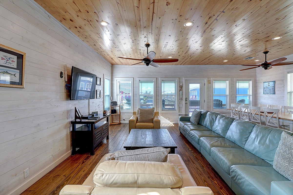 Relax in your spacious living room with cozy seating and stunning water views through panoramic windows.