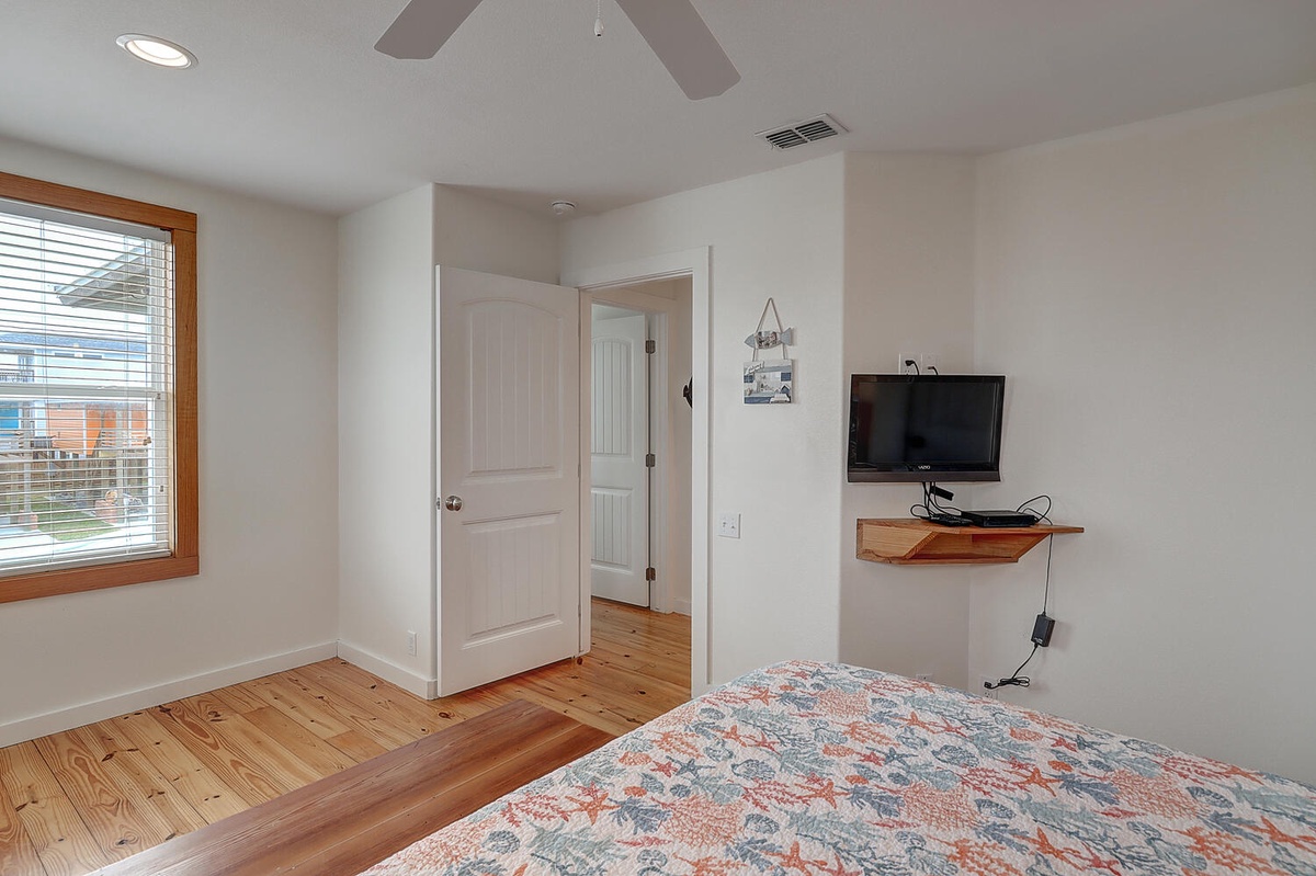 Relax in your bright bedroom with warm hardwood floors, ceiling fan, and wall-mounted TV for cozy nights in.