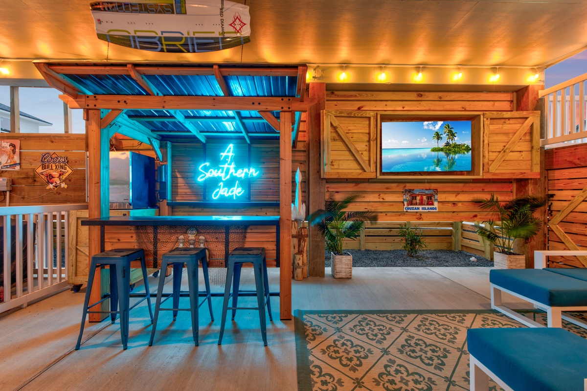 Unwind at your private tiki bar with neon vibes, tropical touches, and a large TV for movie nights under ambient string lights.