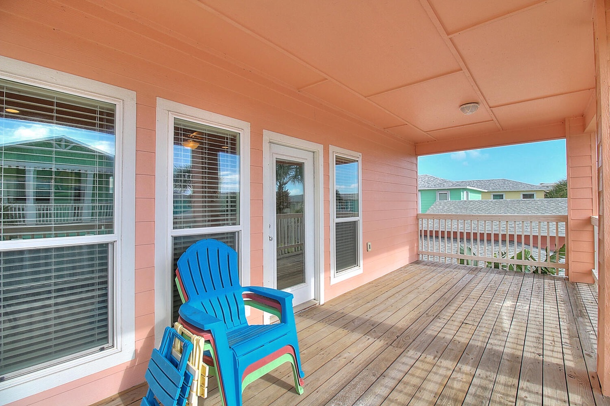 Relax on your private balcony with colorful chairs, perfect for morning coffee or sunset views over the neighborhood.