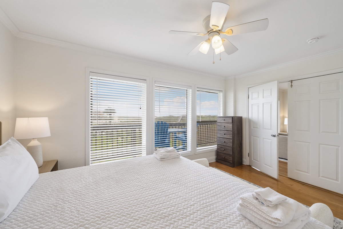 Wake up to stunning water views from your serene bedroom, where crisp linens and a gentle ceiling fan promise comfort. Natural light fills this peaceful retreat, creating the perfect escape.