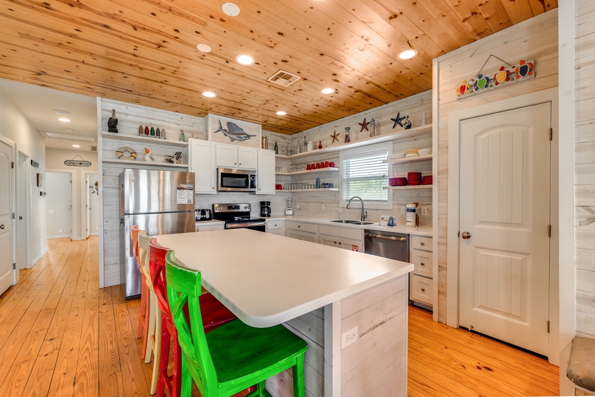 Cook together in this bright, fully-equipped kitchen with charming wood ceilings and colorful island seating.
