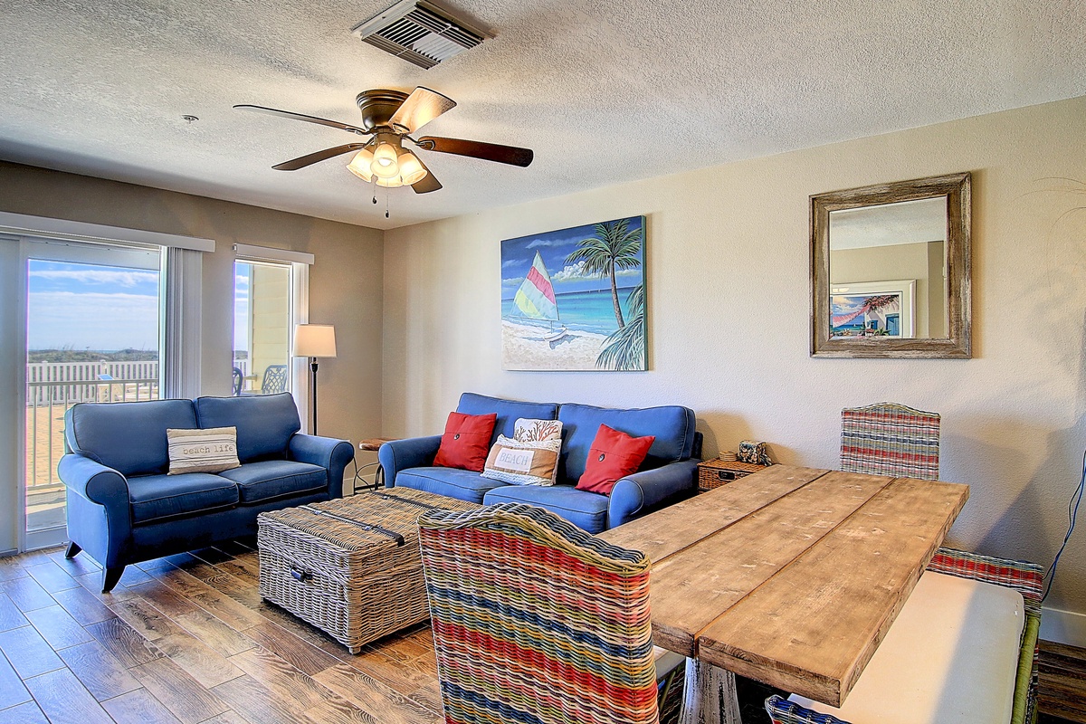 Relax in your coastal-inspired living space with comfortable seating and tropical artwork creating the perfect beach getaway atmosphere.
