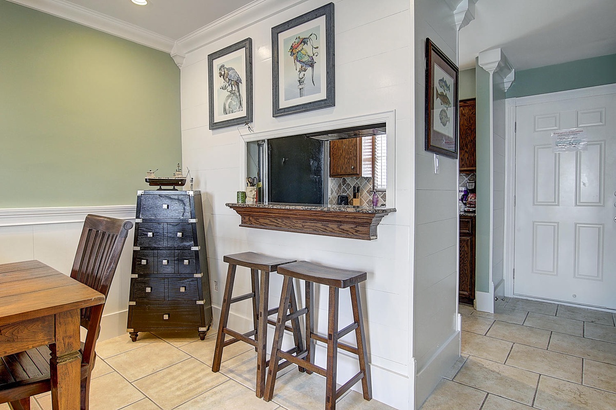 Enjoy your morning coffee at this charming breakfast bar with counter seating and lovely artwork adorning the walls.