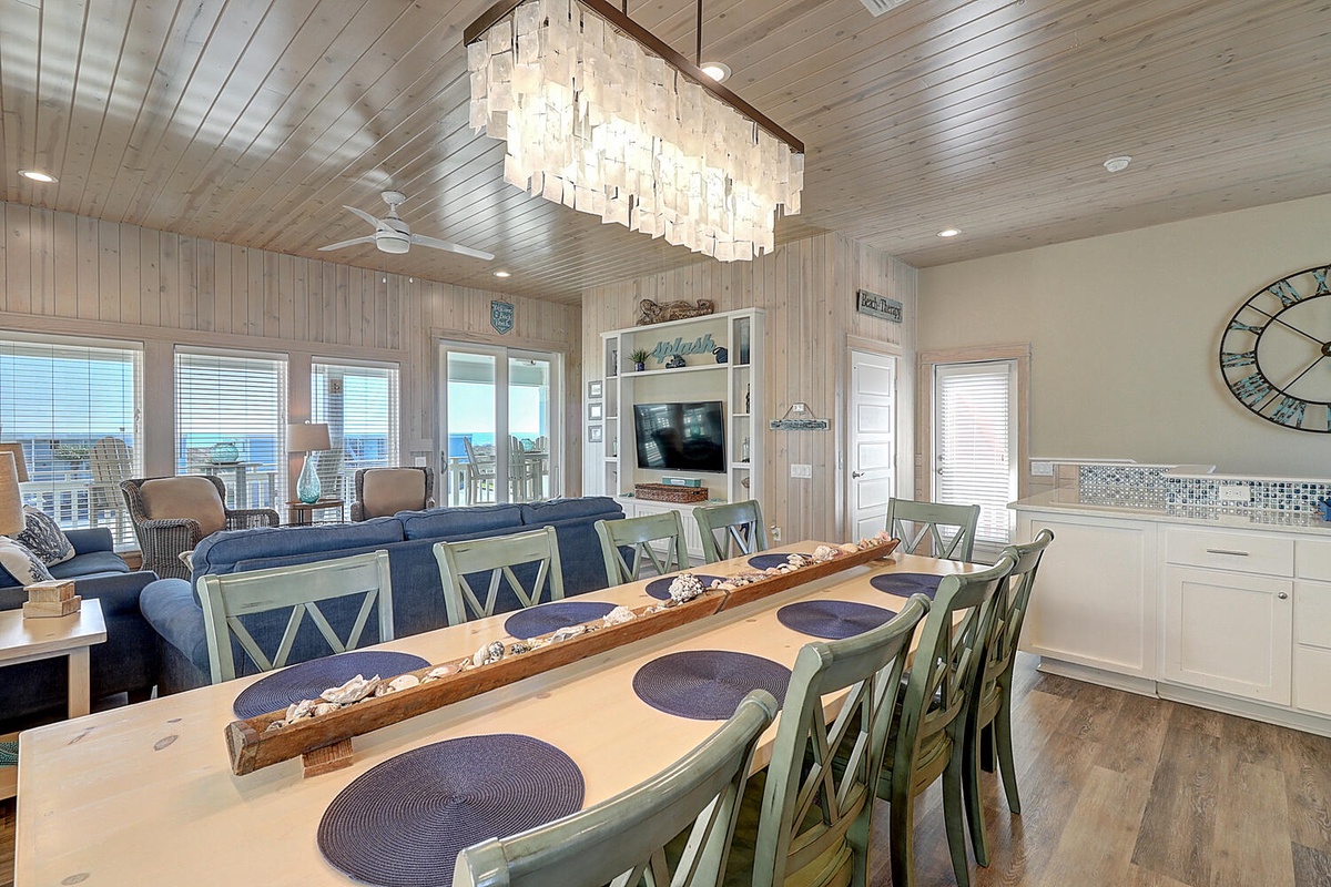 Gather around this stunning dining table where your family meals become cherished memories beneath coastal elegance and sparkling chandelier light.