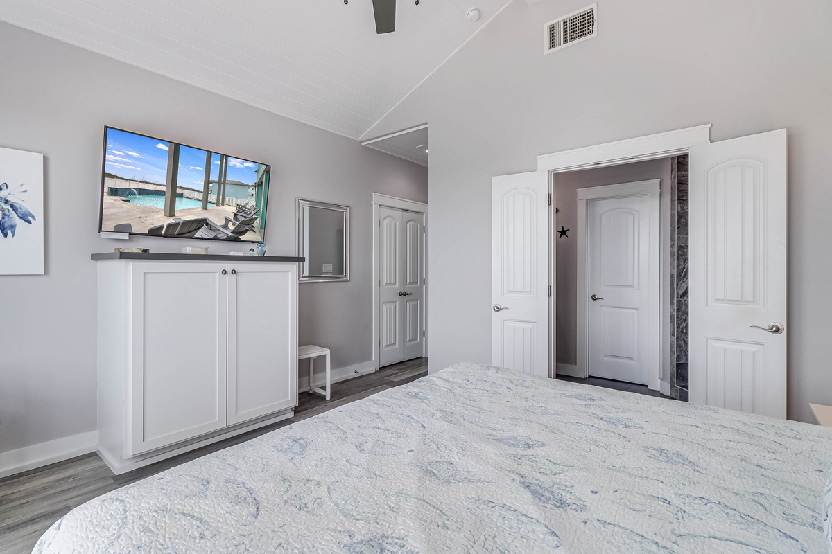 Unwind in your coastal-themed bedroom featuring a wall-mounted TV and ample storage—your peaceful retreat awaits.