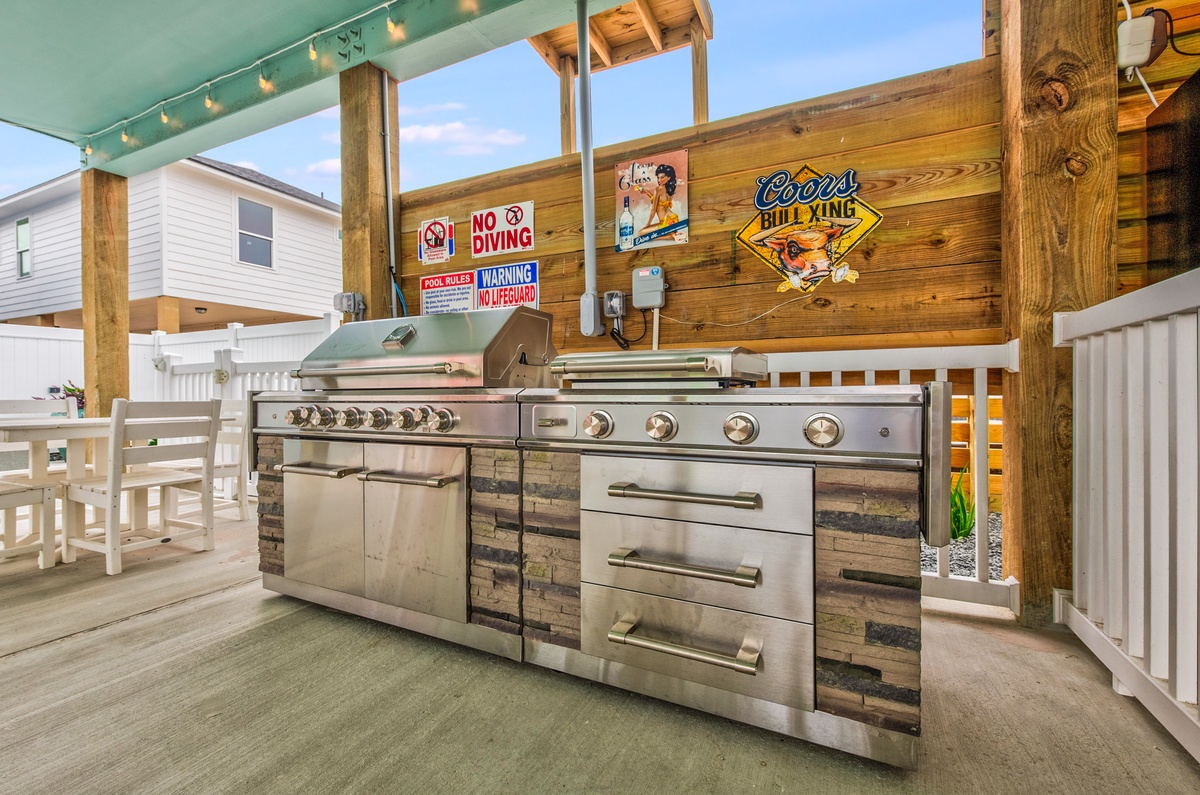 Fire up your culinary skills on this impressive outdoor kitchen with professional-grade grills and ample prep space for memorable poolside meals.