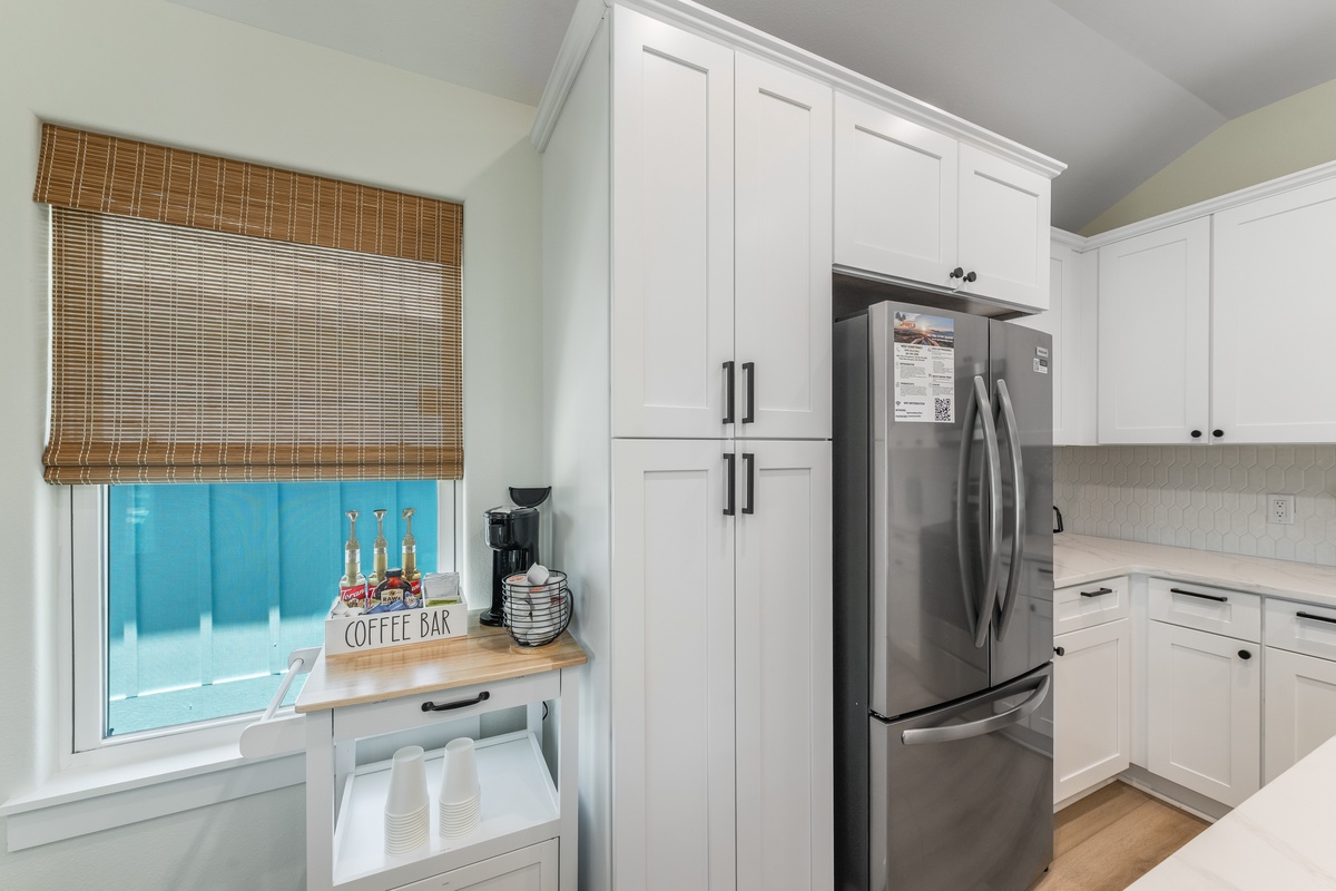 Your fully-equipped kitchen awaits with modern appliances and a charming coffee bar by the window for peaceful morning moments.