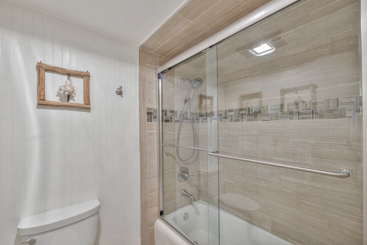 Step into your serene bathroom retreat, where elegant tile work and a glass-enclosed tub create a spa-like sanctuary for your relaxation.