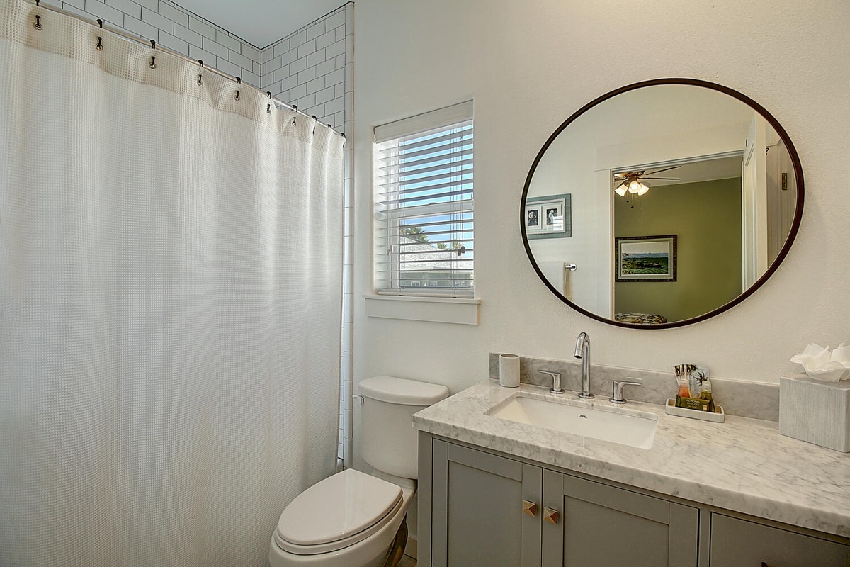 Step into your beautifully appointed bathroom featuring a marble vanity, subway tile shower, and elegant round mirror - perfect for your morning routine.
