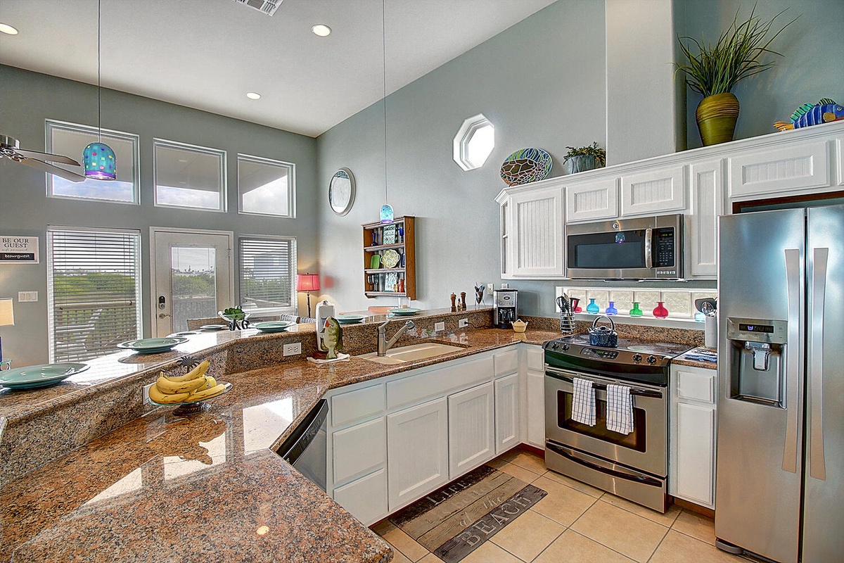 Cook with ease in your spacious gourmet kitchen featuring granite countertops, stainless steel appliances, and abundant natural light streaming through large windows.