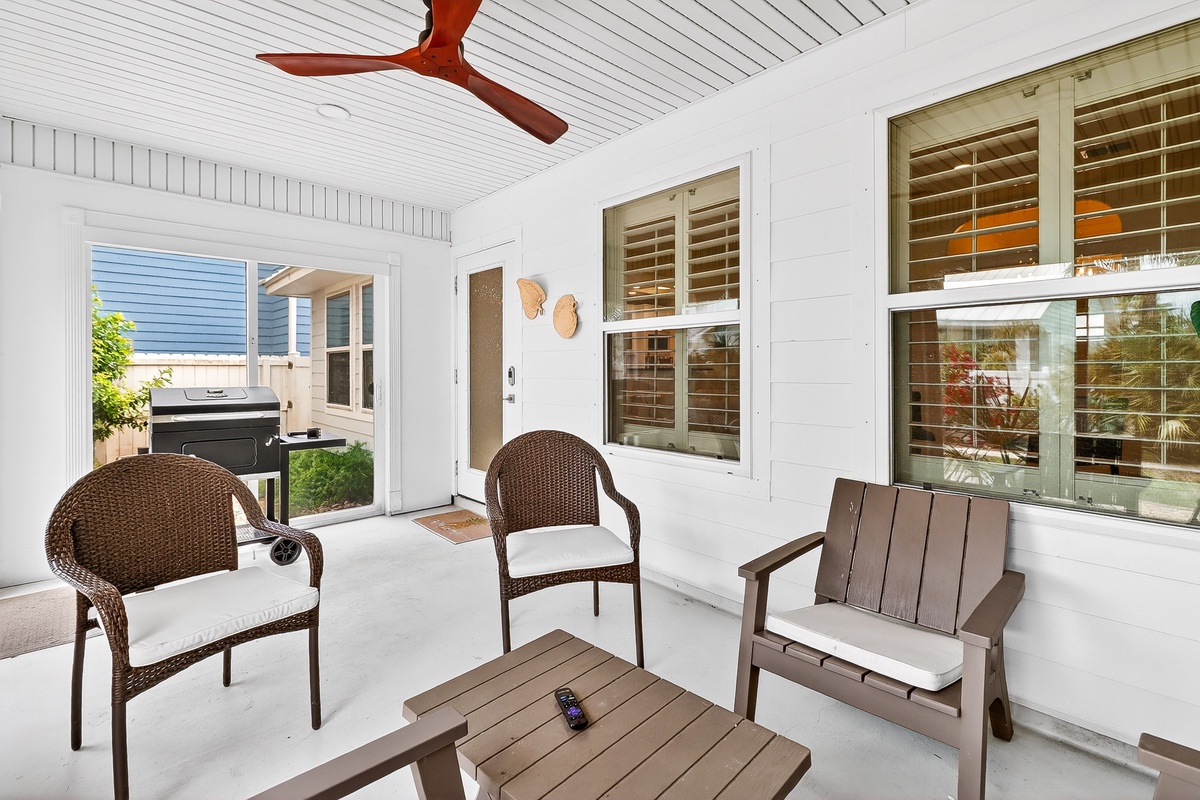 Relax in your private screened porch with comfortable seating and a gentle ceiling fan, perfect for morning coffee or evening unwind time.