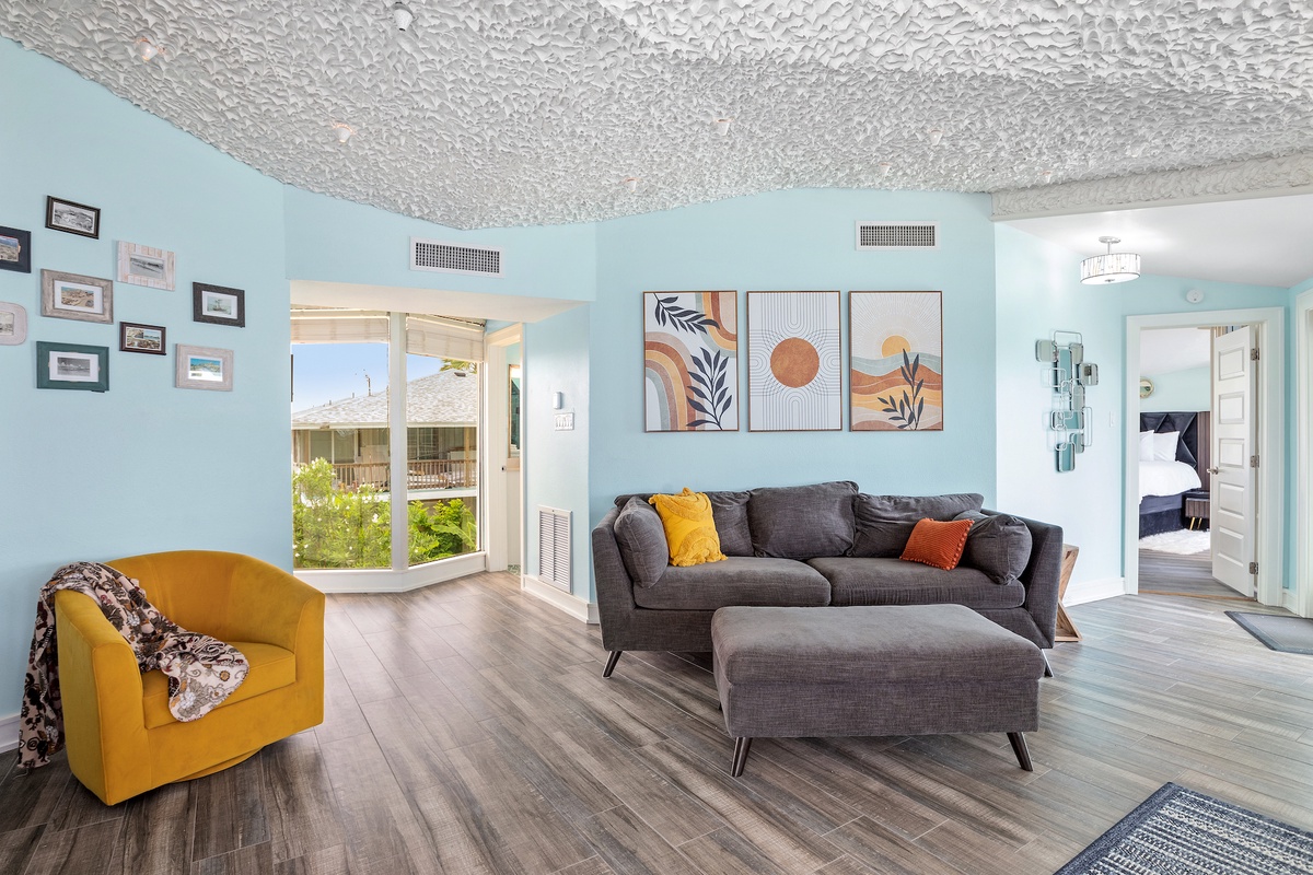 Relax in your stylish living room with plush seating, vibrant artwork, and natural light streaming through large windows.