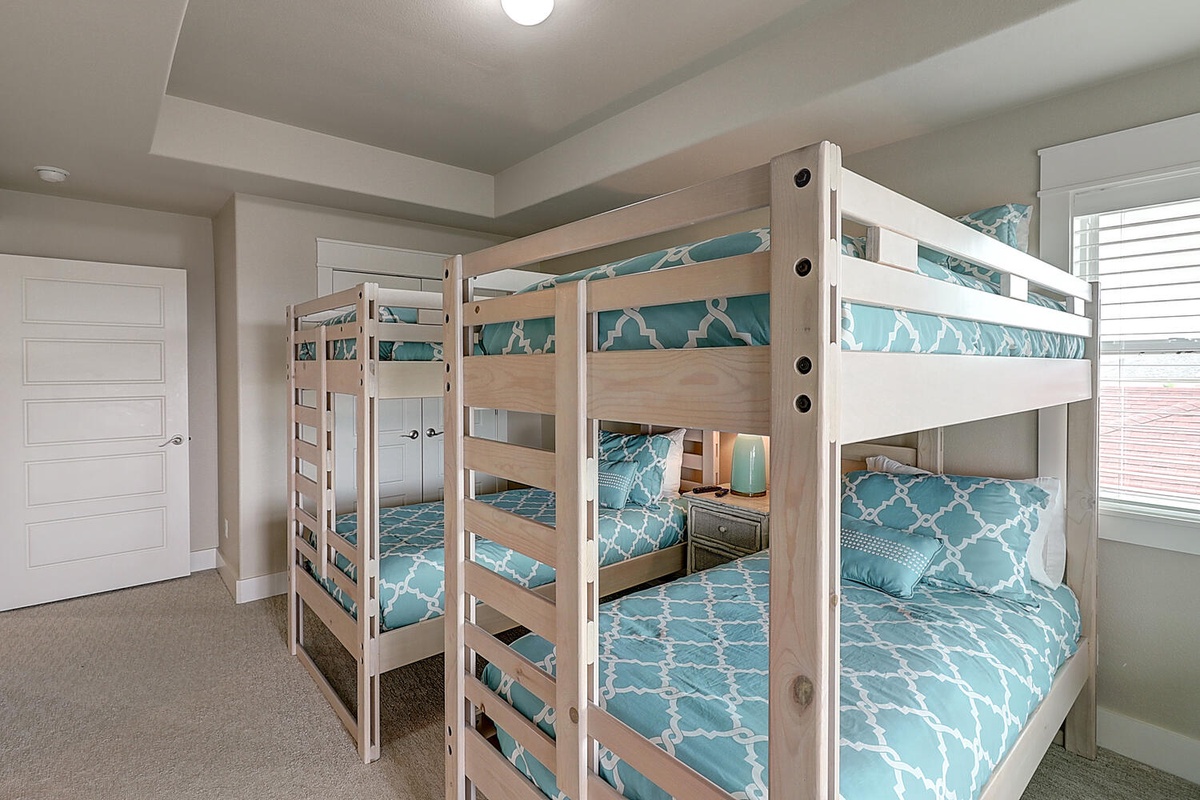 Your bunk room features cheerful blue bedding and built-in reading lights, perfect for families or groups seeking comfortable shared accommodations.
