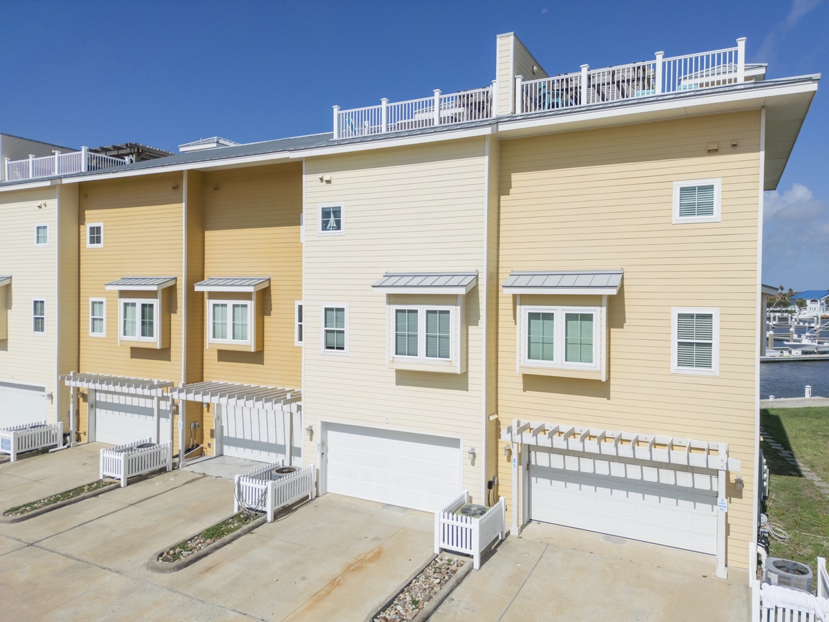 Modern townhomes featuring private garages and rooftop decks, situated directly on the waterfront with marina access.