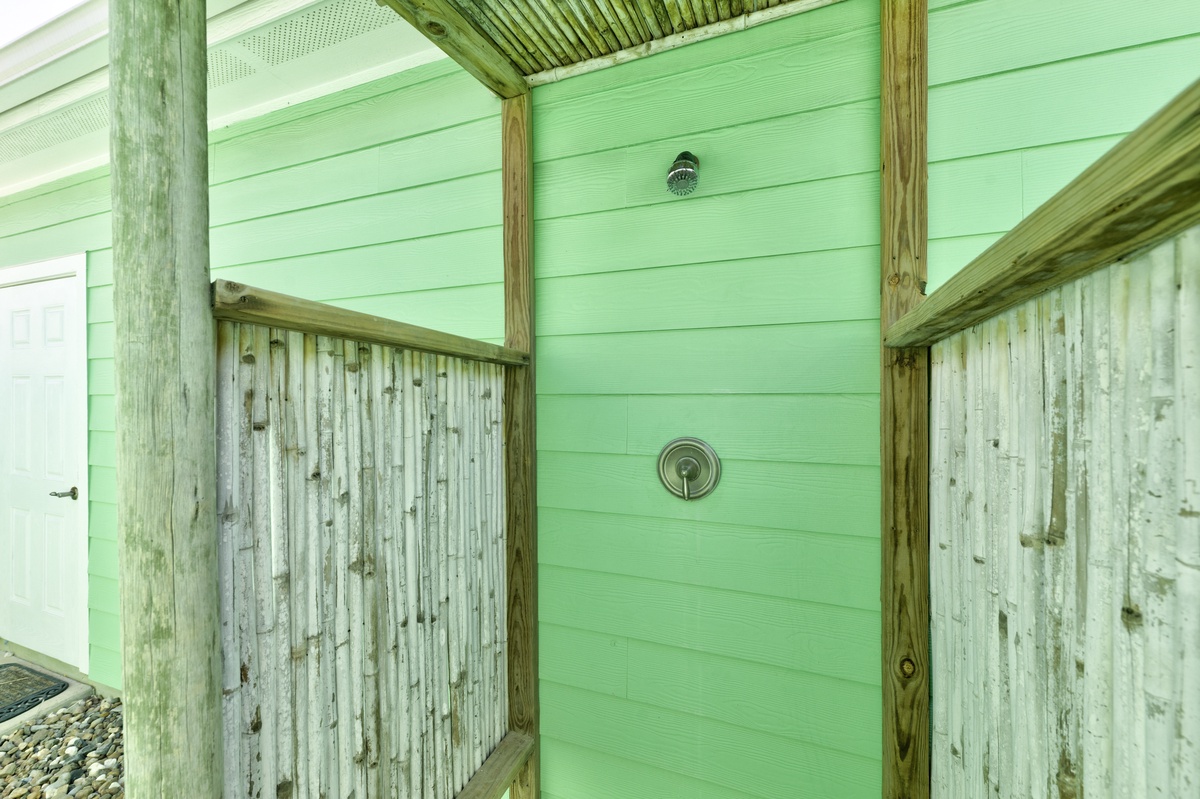 Rinse off salt and sand in your private outdoor shower, surrounded by charming weathered wood and cheerful green walls.